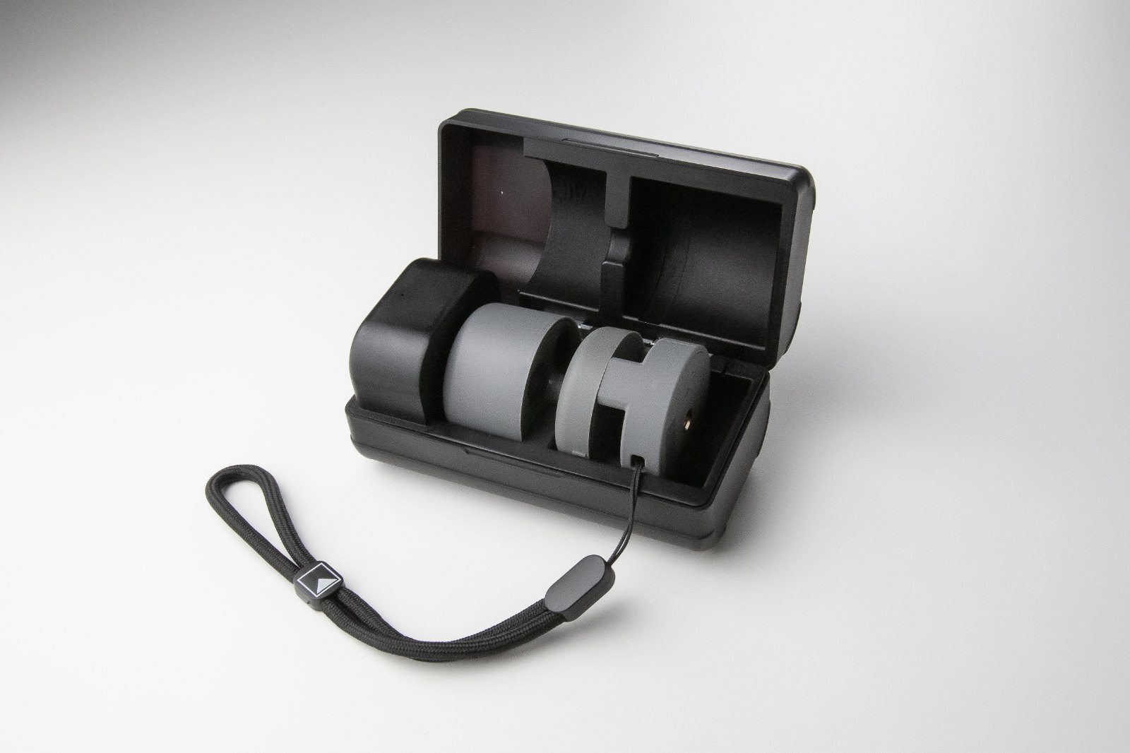 All-in-One seated in the open charging case with wrist lanyard